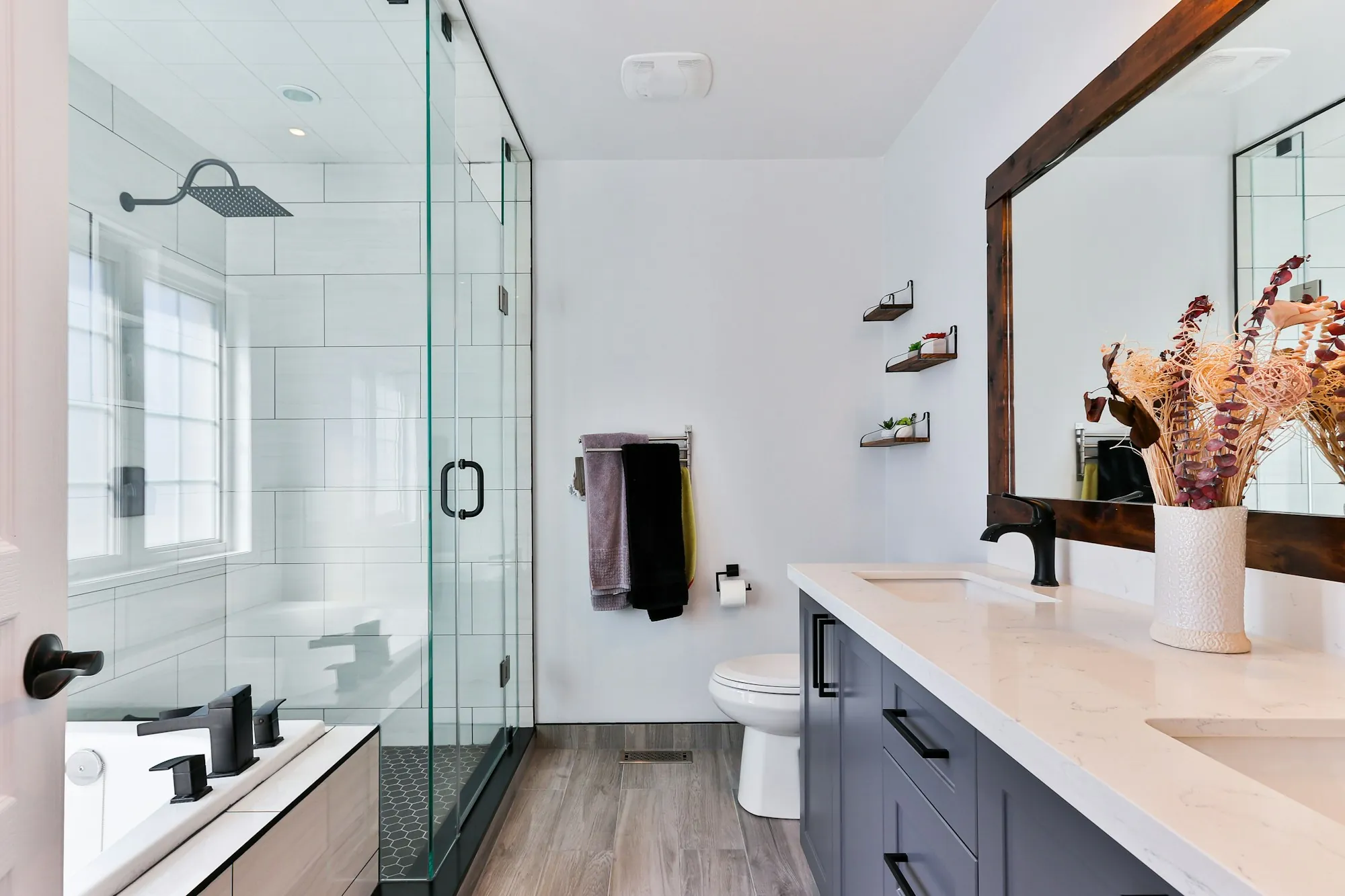 Remodeled bathroom with a glass walk-in shower and a double vanity